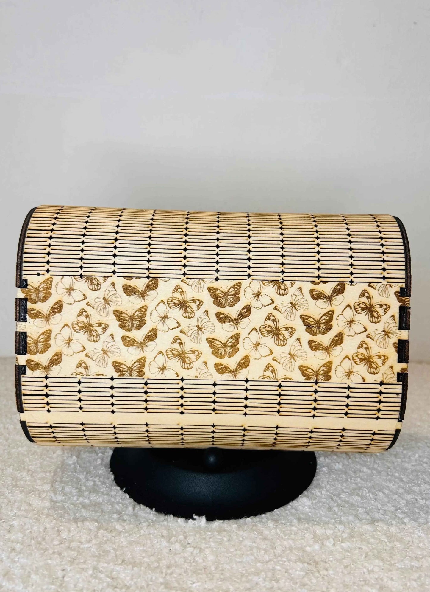 Sac en forme de papillon de la marque Le Bois Elégant, en cuir élégant, visible en détail avec ses couleurs vives et ses poignées.