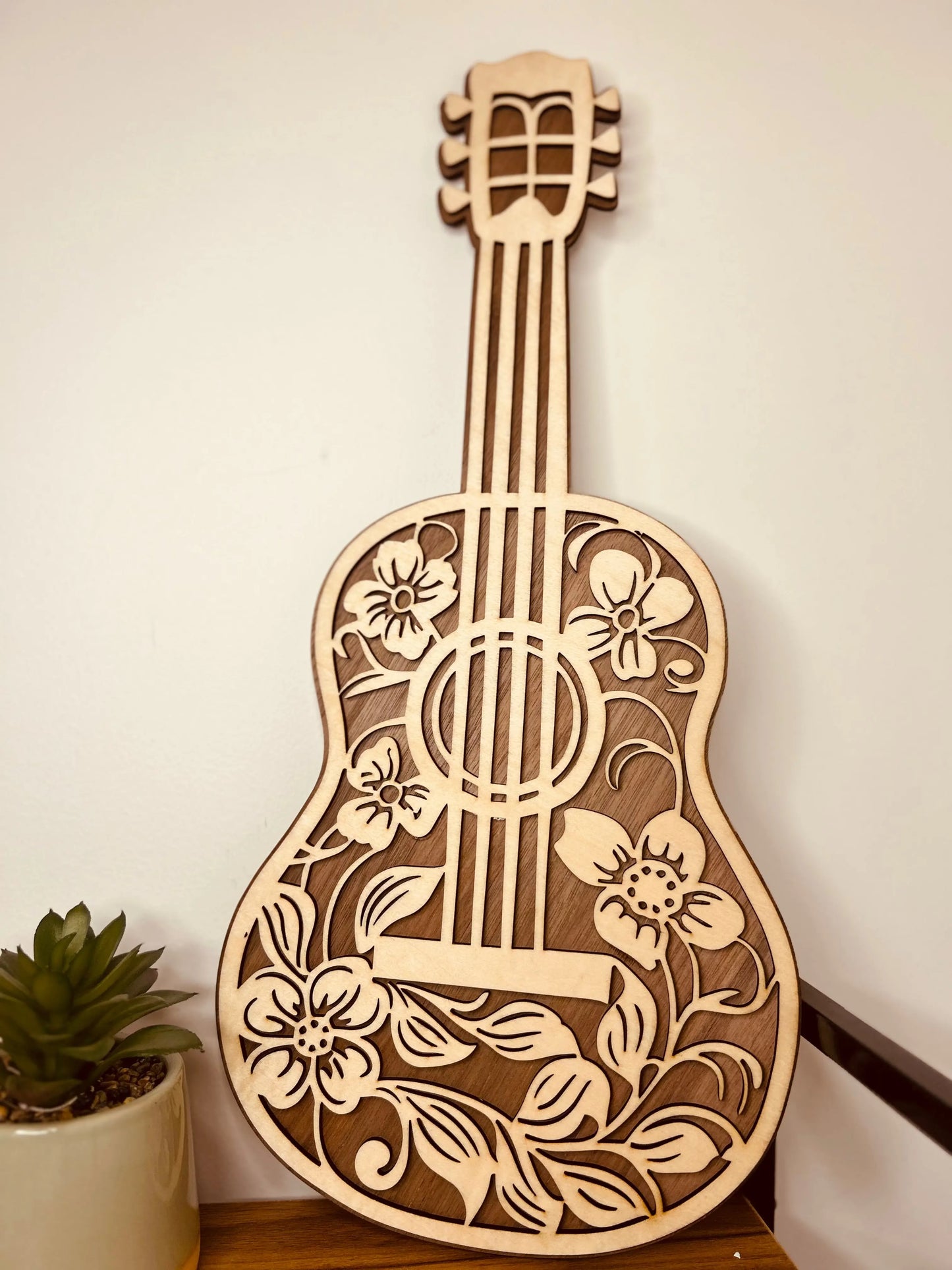 Guitare Décorative en Bois avec Motifs Floraux de Le Bois Elégant, vue d'ensemble montrant sa beauté et sa structure. Ideal comme pièce de GUITARE et élément en BOIS pour la DECORATION, un article de choice pour ceux qui chérissent la MUSIQUE.