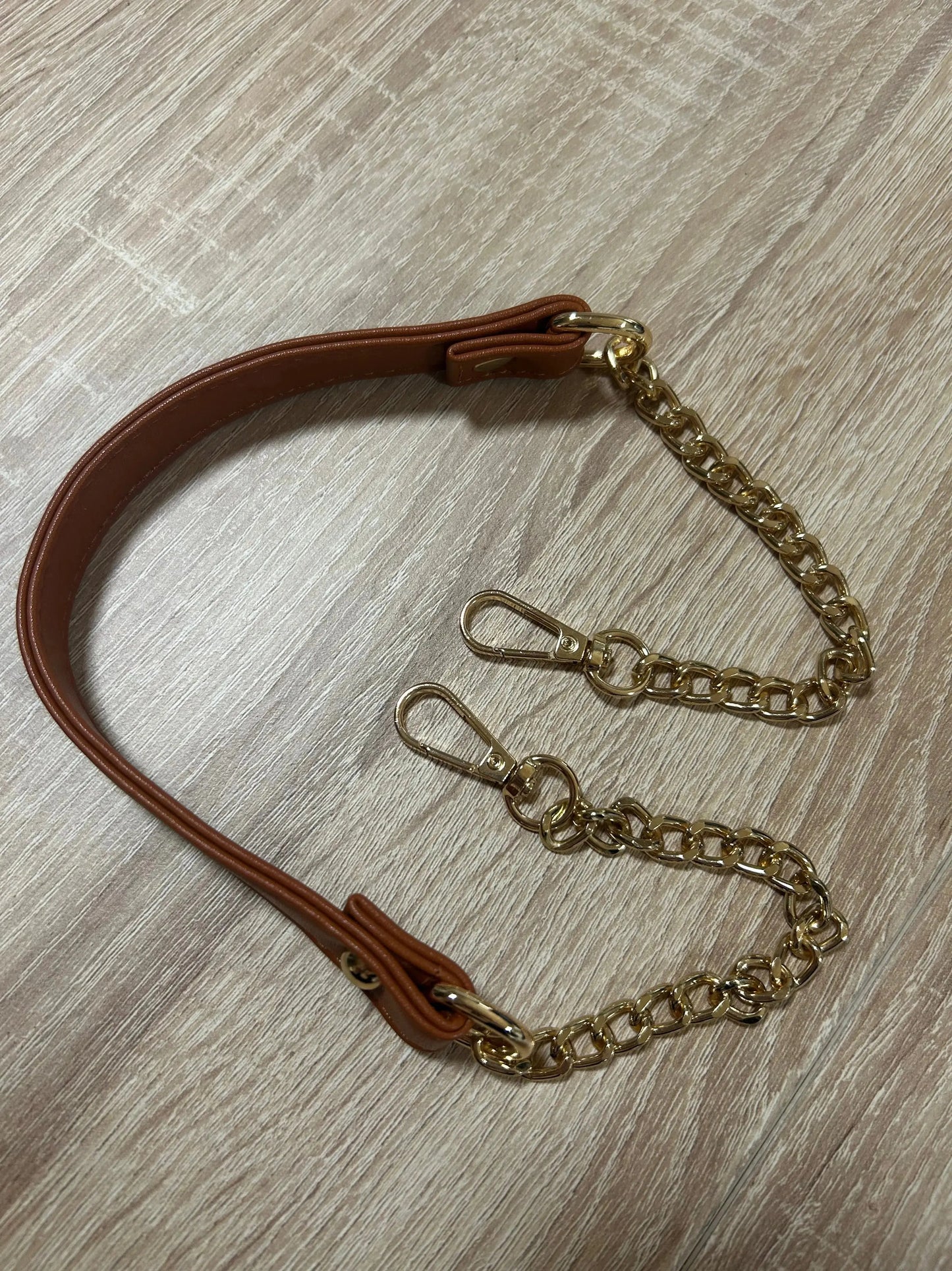 Détail de la bandoulière en cuir et chaîne dorée, accessoire de mode mystique de Le Bois Élégant.