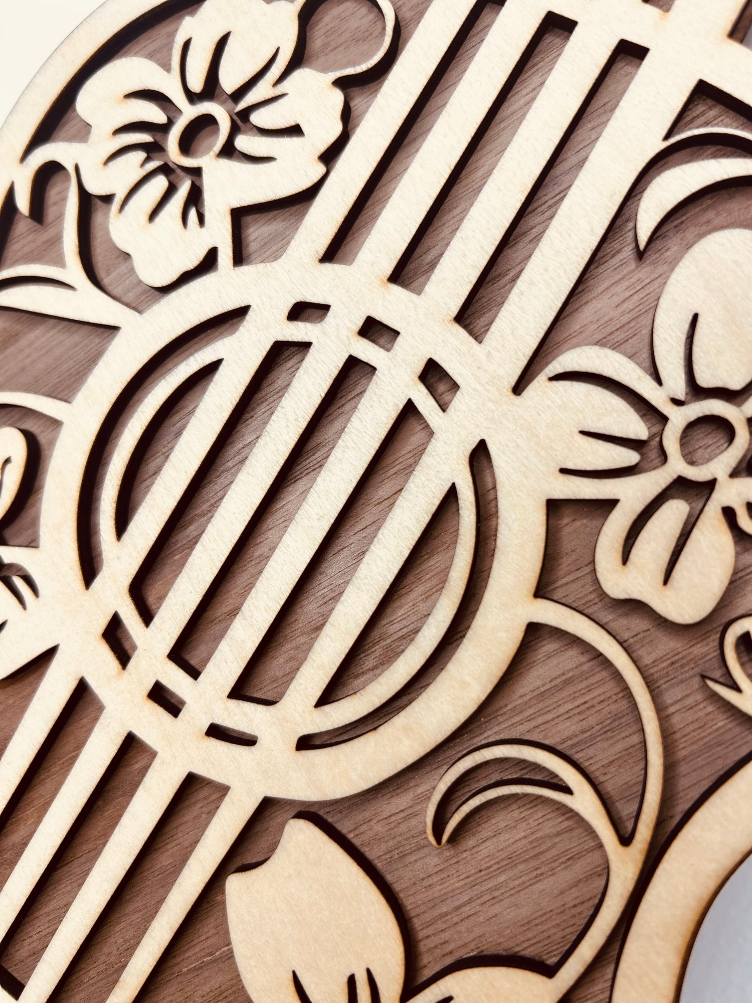 Détails raffinés d'une guitare décorative en bois avec motifs floraux, représentée comme une œuvre d'art élégante, parfaite pour les décorations en bois artisanales.