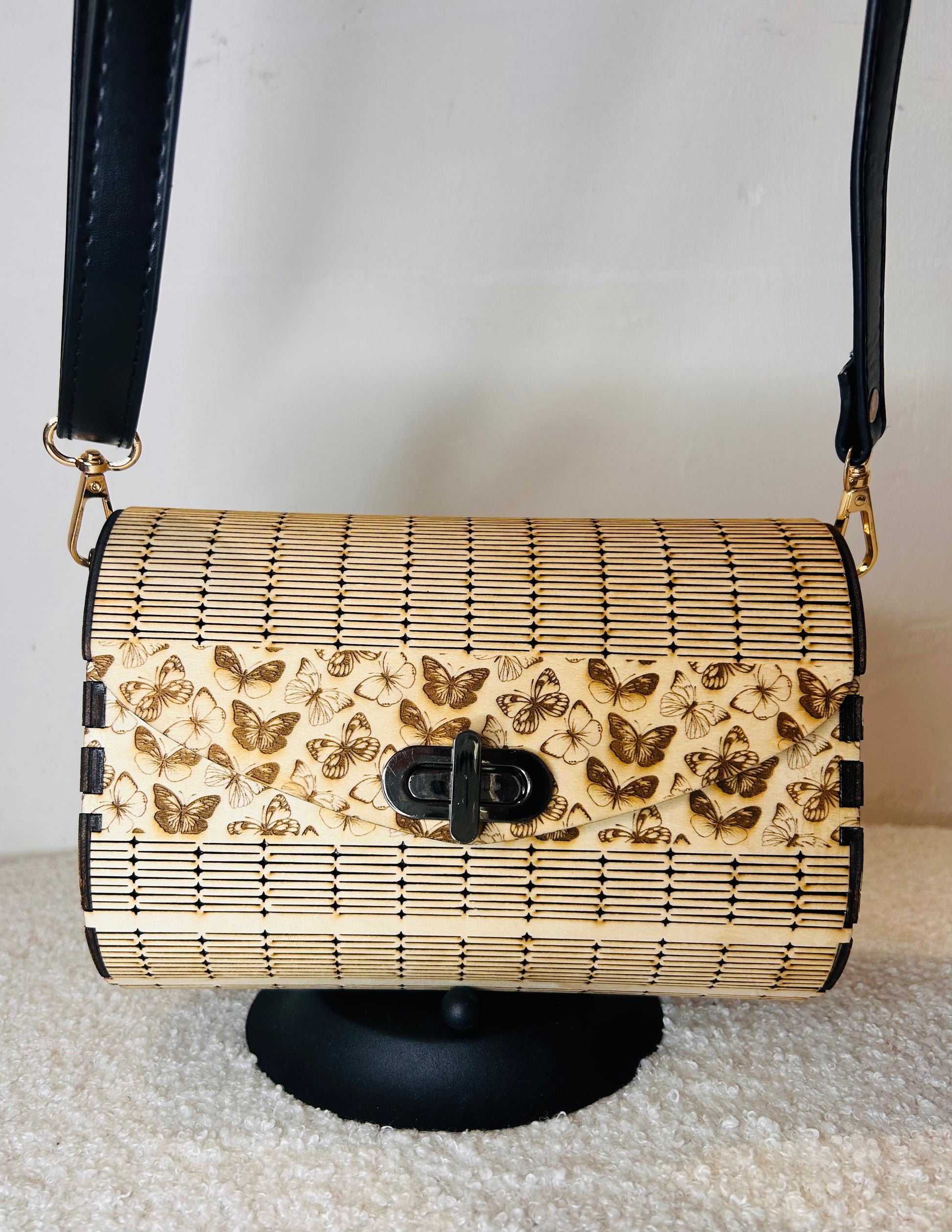 Sac en bois Papillon Élégant de Le Bois Elégant en port de bandoulière, mettant en évidence sa texture en bois unique et son style chic.