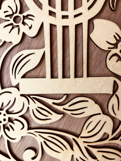 Vue rapprochée des motifs floraux de la Guitare Décorative en Bois avec Motifs Floraux de Le Bois Elégant, illustrant le détail et la finesse du bois. Cette GUITARE décorative en BOIS est parfaite pour enrichir toute DECORATION et pour les passionnés de MUSIQUE.