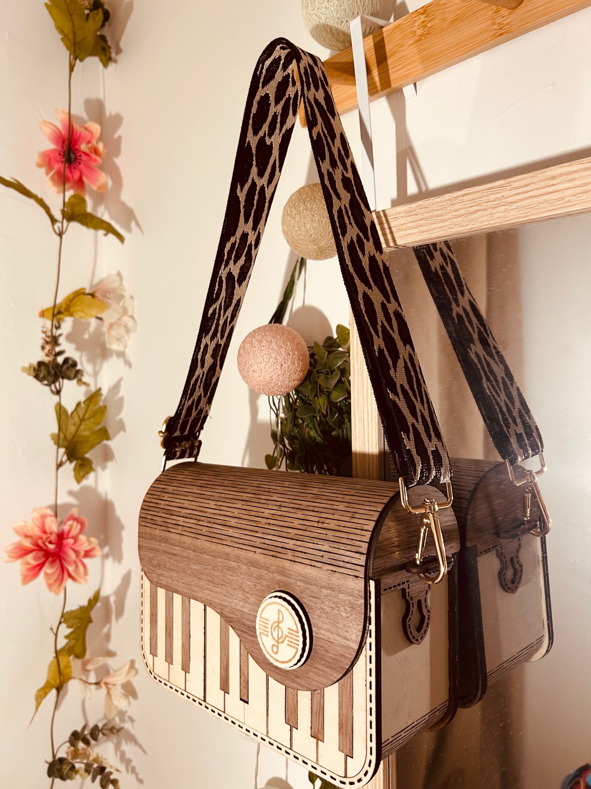 Sac en bois design 'Sac en Bois Piano' de Le Bois Elégant, suspendu avec bandoulière en chaînette, displaying artisan touches qui soulignent le fait que c'est un produit d'artisanat. Sac en bois.