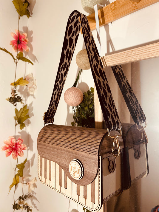 Sac en bois design 'Sac en Bois Piano' de Le Bois Elégant, suspendu avec bandoulière en chaînette, displaying artisan touches qui soulignent le fait que c'est un produit d'artisanat. Sac en bois.