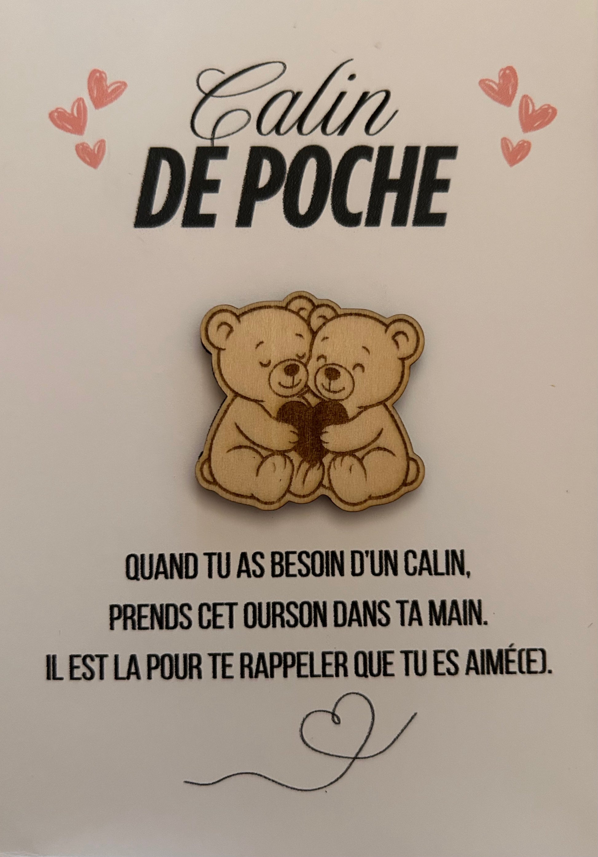 Photo mettant en avant le Câlin de Poche de Le Bois Elégant avec un ourson en bois tenant un cœur sur une carte chaleureuse. Ce geste tendre est un moyen idéal de montrer votre affection et de réchauffer le cœur des autres. calin de poche, pockethug