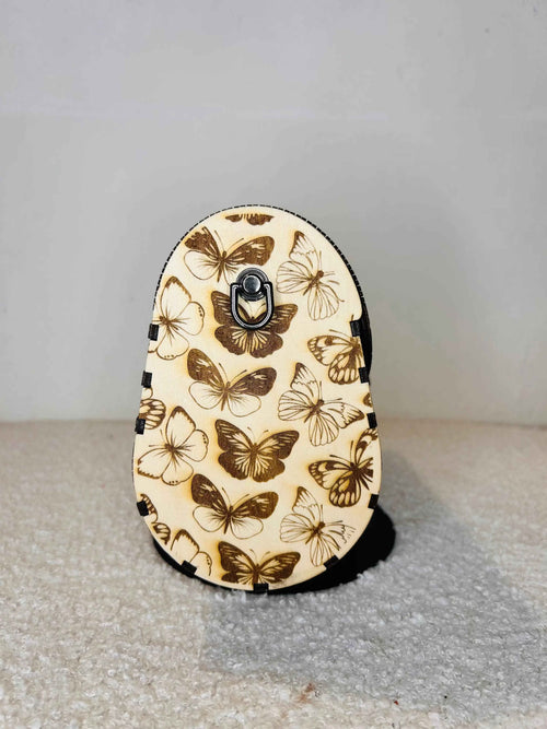 Sac en forme de papillon de la marque Le Bois Elégant, avec détails élégants et design unique, porté ou posé.