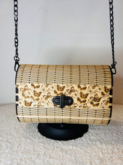 Sac en bois Papillon Élégant de Le Bois Elégant, affiché sur un support avec sa chaîne en métal noir, parfait pour les soirées élégantes.