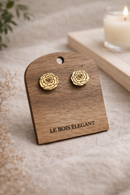 Boucles d’oreilles Rosalie en bois élégant avec détails fins, portées sur une main avec fond neutre.