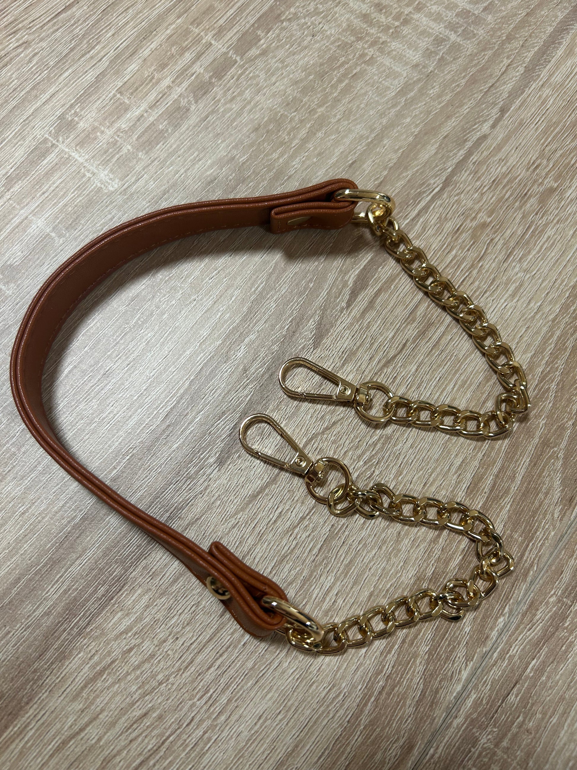 Détail de la bandoulière en cuir et chaîne dorée, accessoire de mode mystique de Le Bois Élégant.