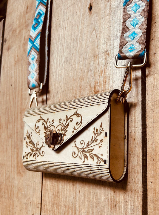 Sac à main écologique SAC EN BOIS NELL de Le Bois Elégant, avec un design floral, accroché sur un mur en bois, symbole de l'artisanat en bois et d'ARTISANAT.