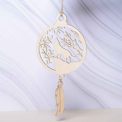 Attrape-rêves en bois de la marque Le Bois Elégant, avec des plumes et perles, suspendu dans un décor naturel.